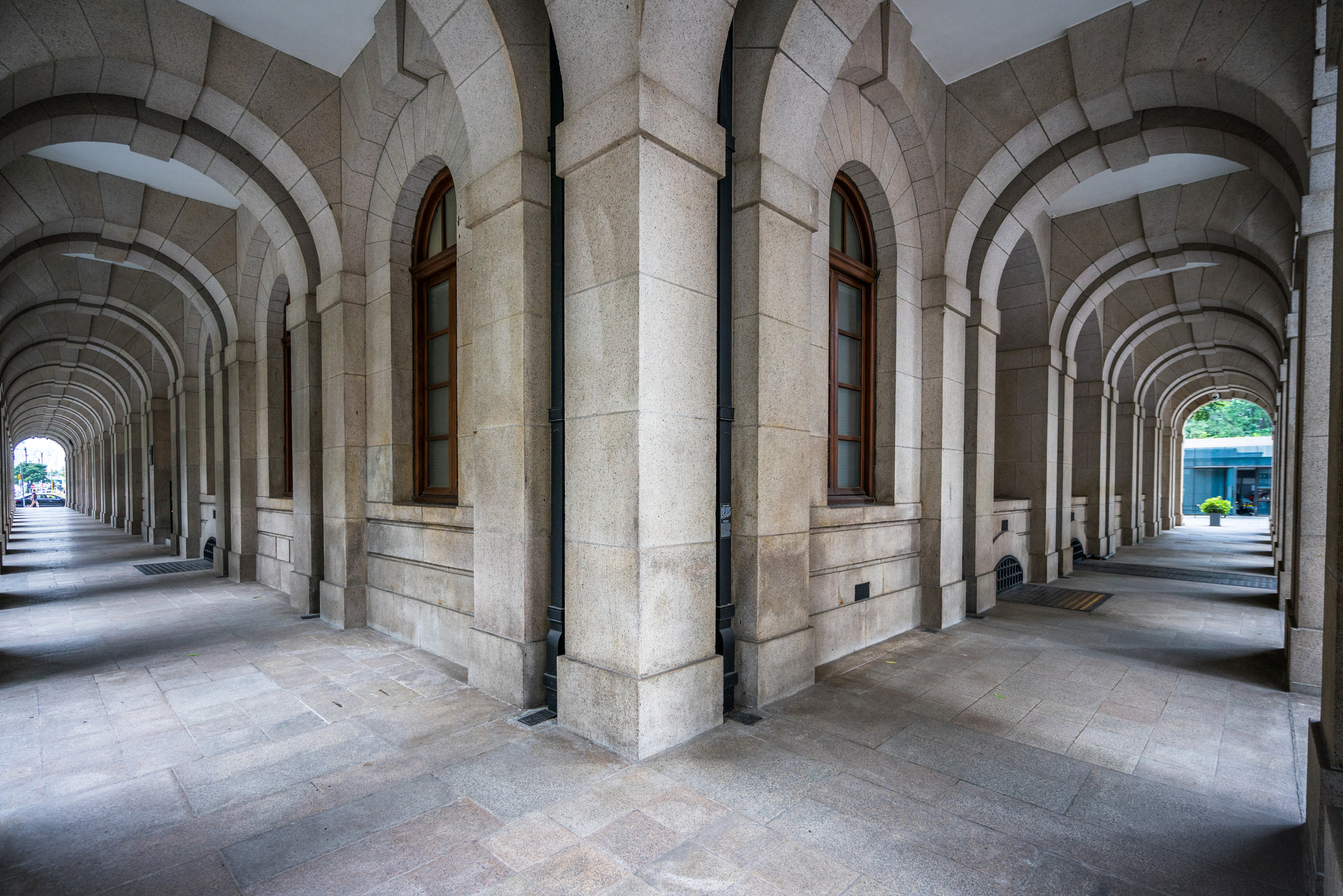 A hallway corridor that diverges into two separate paths, representing the gap between how institutions say they operate and how they actually do